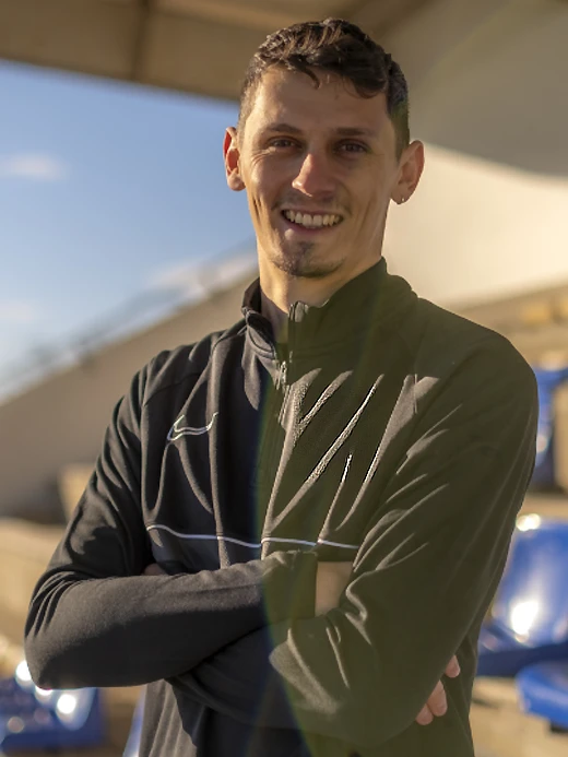 Portrait souriant de Léo-Paul Sapet, préparateur mental, sur un terrain de sport