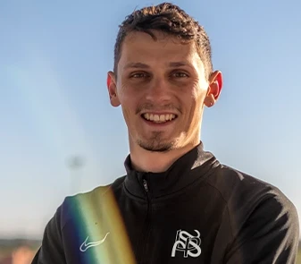 84 Portrait souriant de Léo-Paul Sapet, préparateur mental, sur un terrain