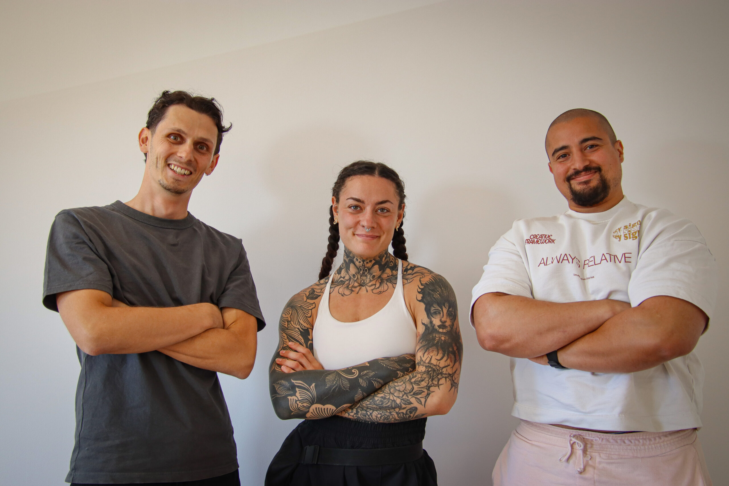 Léo-Paul avec deux joueurs du FCBJ devant le mur média du club avec les logos sponsors